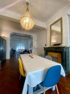 a dining room with a table and chairs and a chandelier at Maison de Maître L Oustal des Halles avec salle de cinéma, billard & Jacuzzi in Castelnaudary