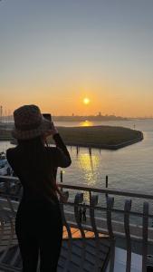 a woman taking a picture of the sunset at Appartamenti Bellavista 107 in Chioggia