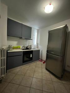 a kitchen with a stainless steel refrigerator and a tile floor at CentoMetri Open in San Massimo