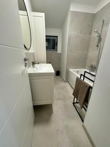 a white bathroom with a sink and a bath tub at NINOA holidays in Petrcane +35 photos