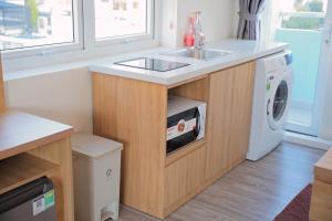 a kitchen with a sink and a washing machine at Nha Trang Center Point in Nha Trang