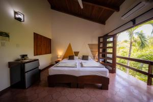 a bedroom with a bed and a large window at Villa Del Sol Boutique Hotel in Coco