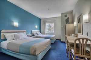 um quarto de hotel com duas camas e uma secretária em Motel 6-London, ON - Ontario em London