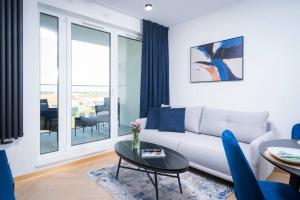 a living room with a couch and a table at Centaurus 144 by RENT4YOU in Olsztyn