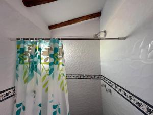 a bathroom with a shower with a shower curtain at Cosy Private Room In A Community Home - A Space To Remember You In Andean Mountains in Pisac