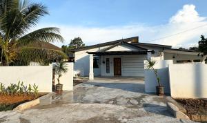 a white house with a gate and a driveway at JAMBU MANIS STAY- Business Traveller Friendly, Family Comfort, Kuala Berang- Free Netflix,Wifi in Kuala Berang