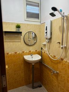 a bathroom with a sink and a mirror at JAMBU MANIS STAY- Business Traveller Friendly, Family Comfort, Kuala Berang- Free Netflix,Wifi in Kuala Berang +24 photos