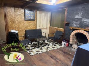 a living room with two chairs and a fireplace at Quinde Ñan Lodge in Papallacta