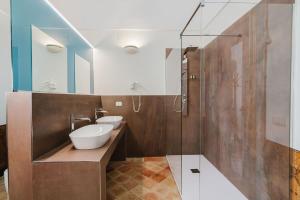 a bathroom with two sinks and a glass shower at La Casa di Ele in Matera +160 photos