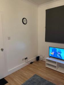 a living room with a flat screen tv and a blackboard at HIVESTAYS Free Wi-Fi, Smart TV, Parking, Tea &Coffee in Kettering