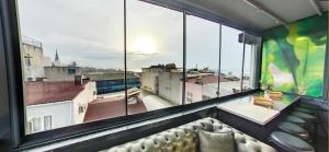 a room with a couch in front of a large window at Elibol Hotel Old City in Istanbul