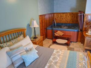 a bedroom with a bed and a tub at Springbrook Inn AuSable in Houghton Lake