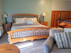 a bedroom with a large bed and a couch at Springbrook Inn AuSable in Houghton Lake +1 photo