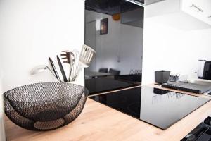 a kitchen with a black bowl on a counter at Suite POP 92 proche gare, stade de France, Parking in Osny