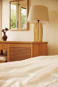 a bedroom with a bed with a lamp and a dresser at Agali Hotel Paxos in Gaios
