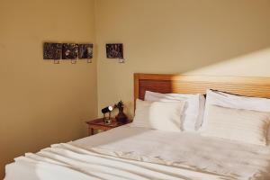 a bedroom with a bed with white sheets and pillows at Agali Hotel Paxos in Gaios +121 photos