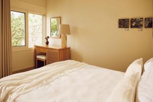 a bedroom with a bed and a desk and a window at Agali Hotel Paxos in Gaios