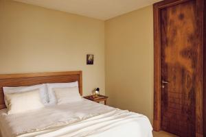 a bedroom with a bed and a wooden door at Agali Hotel Paxos in Gaios