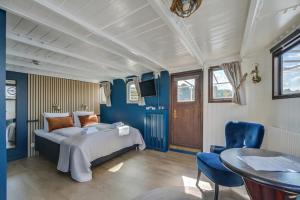 斯德哥尔摩Mälardrottningen Yacht Hotel的一间拥有蓝色墙壁的卧室,配有一张床和一张桌子