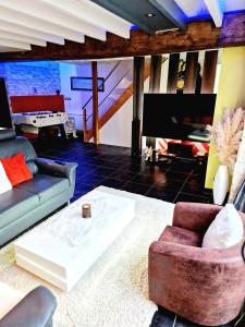 a living room with a couch and a tv at Maison cosy piscine jacuzzi sauna in Épervans