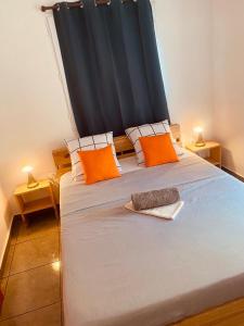 Un dormitorio con una cama grande con almohadas naranjas. en BUNGALOW Terakota, en Deshaies 7 fotos más
