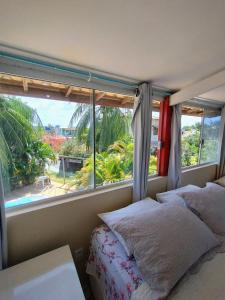 a bedroom with a bed and a large window at Pousada Caribe in Itacimirim +98 photos