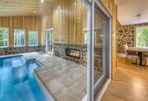 an indoor swimming pool with a fireplace in a house at Les Chalets Immersion in Saint-Raymond
