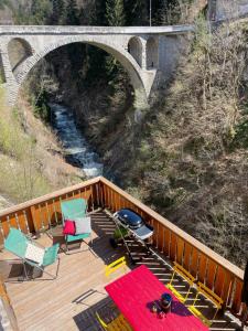a deck with chairs and a grill and a bridge at Espace Diamant - Duplex typiquement Savoyard in Flumet +4 photos