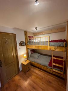 a bedroom with two bunk beds and a door at Espace Diamant - Duplex typiquement Savoyard in Flumet