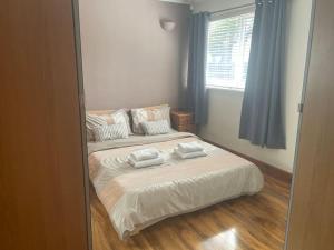 a bedroom with a bed with two towels on it at Cute Cottage Central Bathgate Inc Sofa Bed in Bathgate