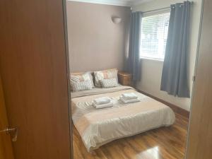 une chambre avec un lit avec deux oreillers dessus dans l'établissement Cute Cottage Central Bathgate, à Bathgate