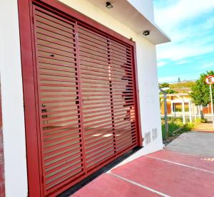 a red garage door on the side of a house at Casa Loft da Orla in Barra Bonita