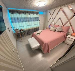 una camera da letto con un letto rosa e una finestra di Gold House Oro a Hacienda Mera