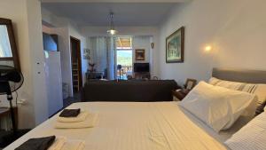 a bedroom with a large white bed and a living room at Konti villa in Kondáraina