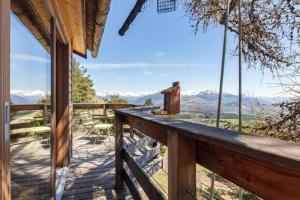 a wooden deck with a view of the mountains at Cabane perchée avec sauna en pleine nature in Gap
