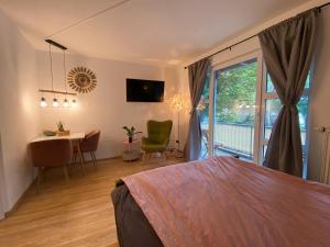 a bedroom with a bed and a table and a window at Salí - Essen - Studioapartments in Essen