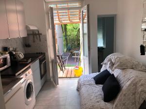a kitchen with a bed and a door to a patio at La rivière (appartement 25m2 ) in Lisieux