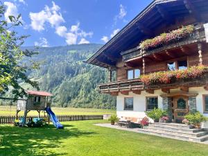 a house with a slide and a playground at Apartment Katharina Schneeberger in Zell am Ziller