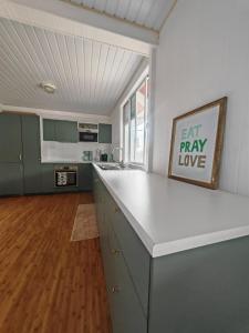 a kitchen with a white counter top in a room at Pitate Surf House in Atimaono +6 photos