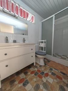a bathroom with a toilet and a sink and a mirror at Pitate Surf House in Atimaono +6 photos