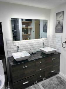 Un baño con dos lavabos y un espejo grande. en Room in smart home with pond view, en Orlando
