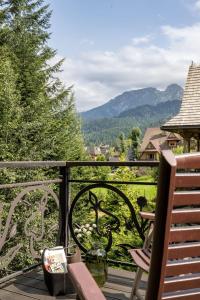 een balkon met een bank en uitzicht op de bergen bij Rezydencja Sywarne Lux Spa in Kościelisko