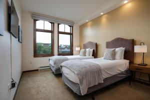 Dos camas en una habitación con dos ventanas. en Expansive Luxury Condo - Downtown - Summer AC, en Steamboat Springs