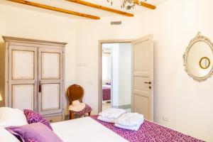 une chambre avec un lit et un miroir au mur dans l'établissement Tenuta Fiumara, à Marina di Grosseto