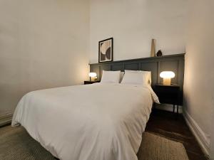 a bedroom with a large white bed with two lamps at La Puerta Roja in Valparaíso +22 photos
