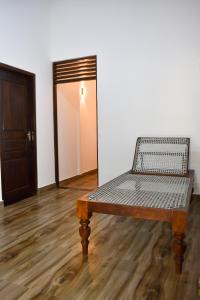 a bench sitting in a room with a door at Wellassa Sisila in Wellawaya