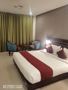 KottaraHotel Emerald Gardens的一间配有大床和桌子的酒店房间