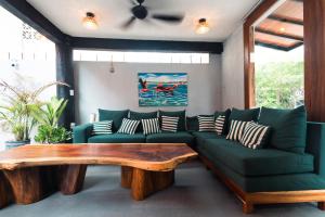 a living room with a green couch and a wooden table at Zihua Mia Hotel Boutique in Zihuatanejo +113 photos