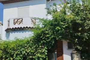 a white house with a tree in front of it at Casa céntrica en Girona in Girona