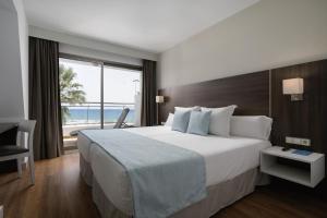 a bedroom with a large bed with a view of the ocean at Alua Golf Trinidad in Roquetas de Mar